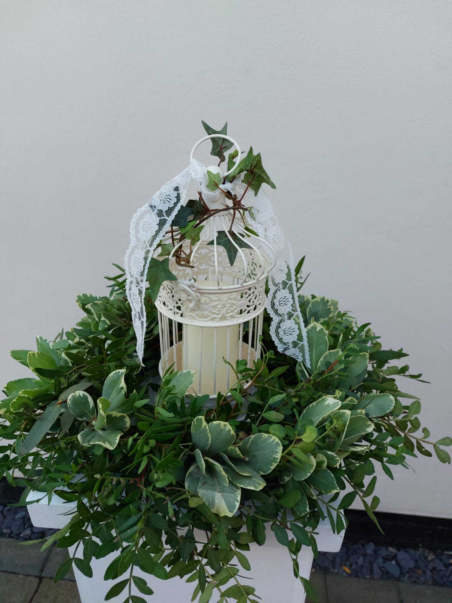Foliage table ring with vintage birdcage and battery operated church candle