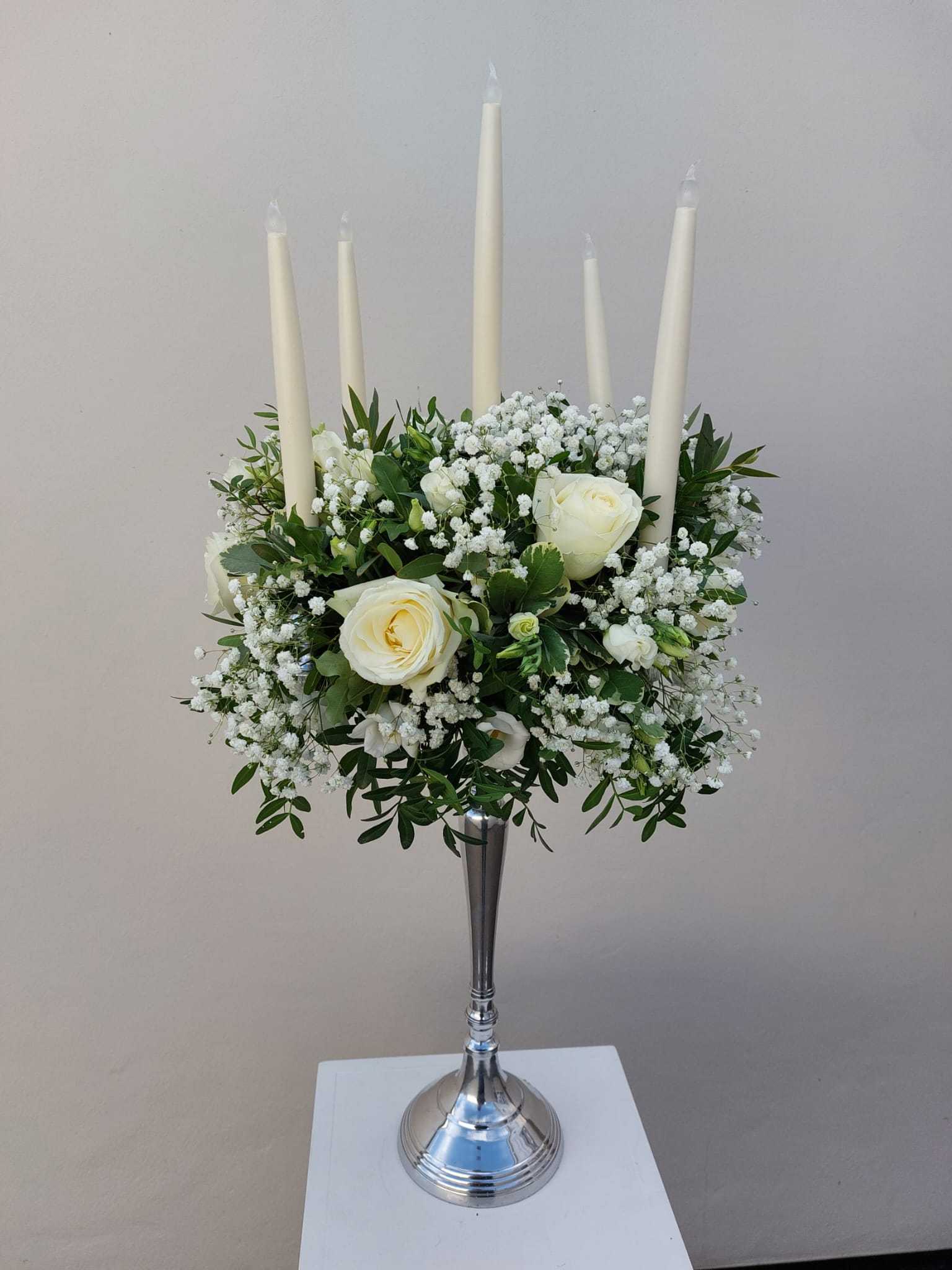 Candelabra with ivory roses mixed foliage and candles